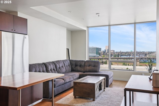 living area with a view of city and light wood finished floors