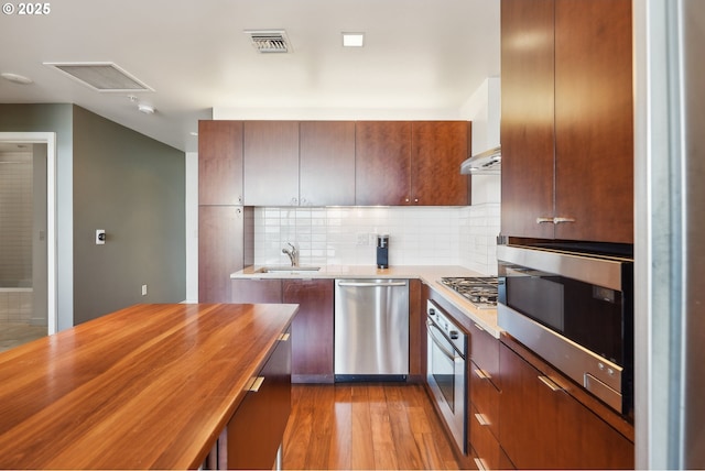 kitchen featuring wooden counters, visible vents, appliances with stainless steel finishes, tasteful backsplash, and a sink