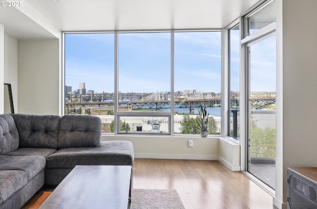 living area featuring baseboards, a city view, a water view, and wood finished floors