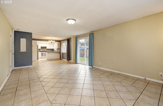 unfurnished living room featuring light tile patterned floors, a textured ceiling, and an inviting chandelier