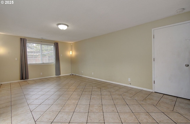 tiled spare room with a textured ceiling