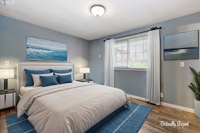 bedroom with wood-type flooring and a textured ceiling