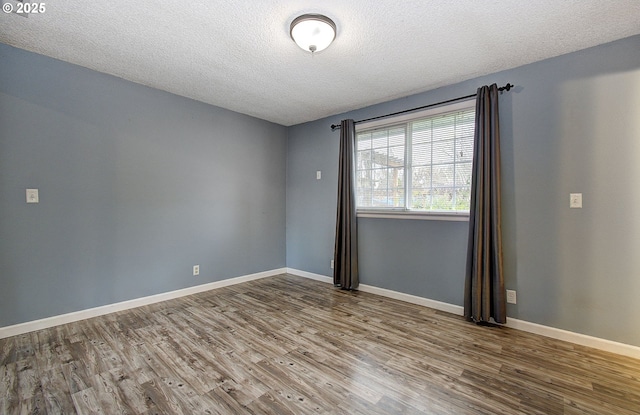 unfurnished room featuring a textured ceiling and hardwood / wood-style flooring