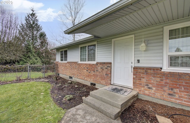 property entrance featuring a lawn