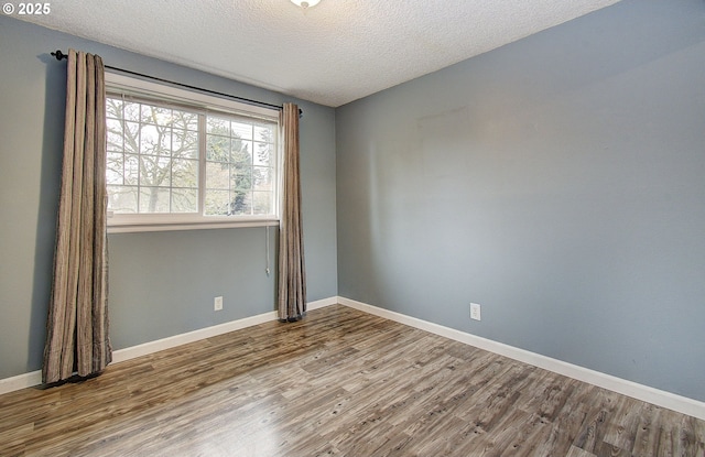 unfurnished room with a textured ceiling and hardwood / wood-style flooring