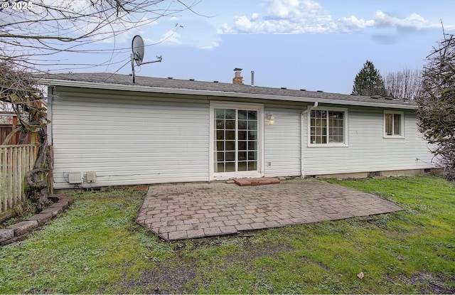 back of house with a patio and a lawn