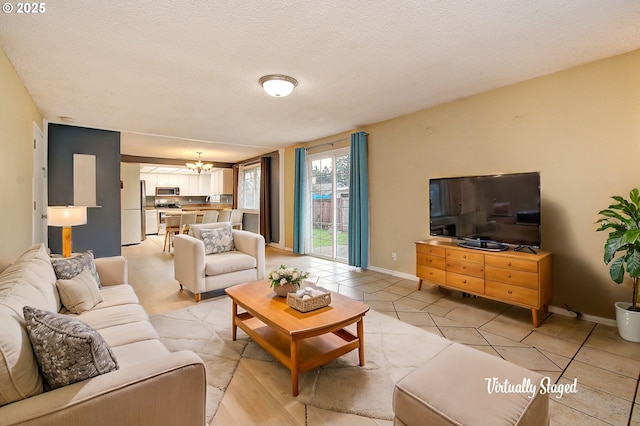 living room with a textured ceiling, a notable chandelier, and light tile patterned flooring