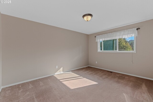 unfurnished room featuring carpet and baseboards