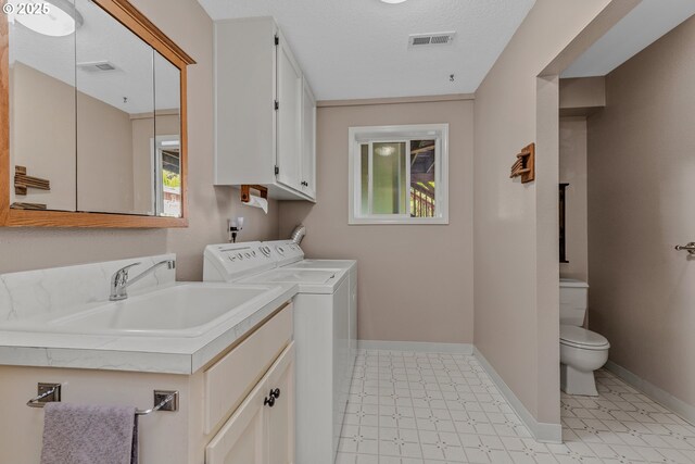 clothes washing area featuring independent washer and dryer, light floors, and baseboards