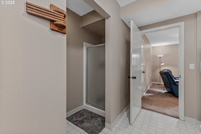 bathroom featuring a stall shower and baseboards