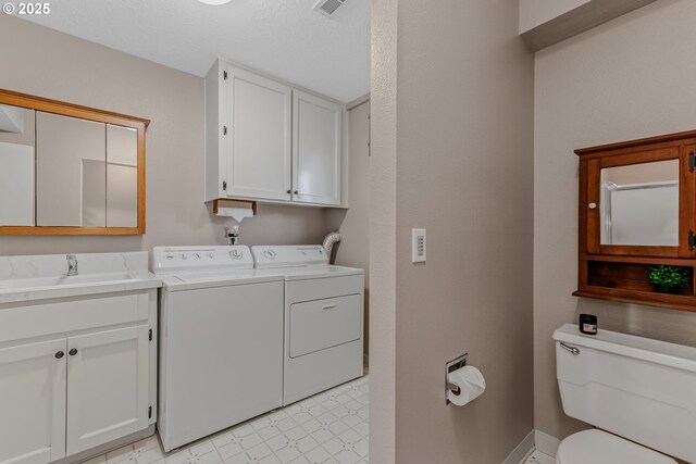 washroom featuring separate washer and dryer, light flooring, a sink, and baseboards