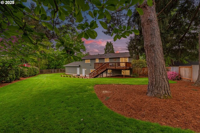 yard at dusk with a wooden deck and stairway