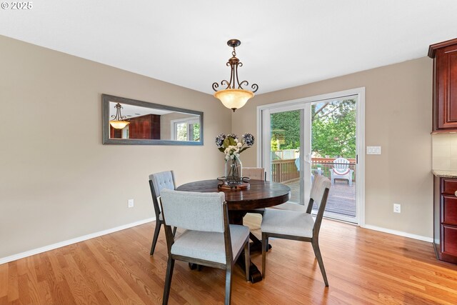 dining area featuring light wood-style flooring, plenty of natural light, and baseboards
