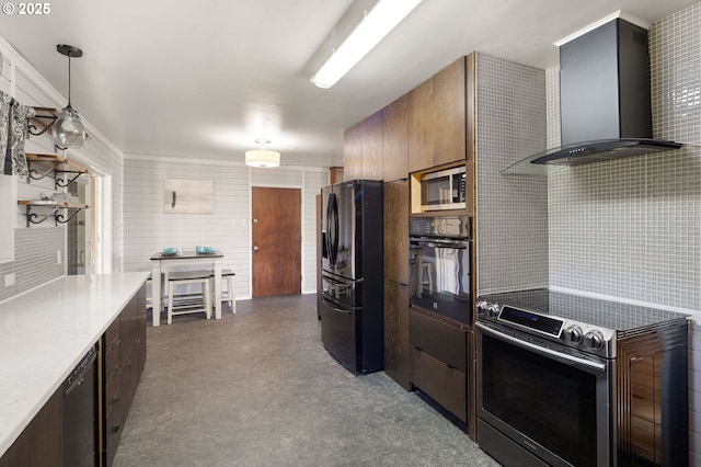 kitchen with backsplash, hanging light fixtures, light countertops, black appliances, and wall chimney exhaust hood