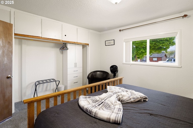 carpeted bedroom featuring a closet and a textured ceiling