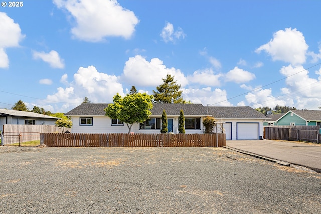 ranch-style house with a garage, a fenced front yard, and concrete driveway
