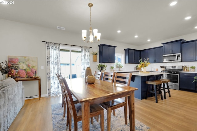 dining space featuring a notable chandelier and light hardwood / wood-style flooring