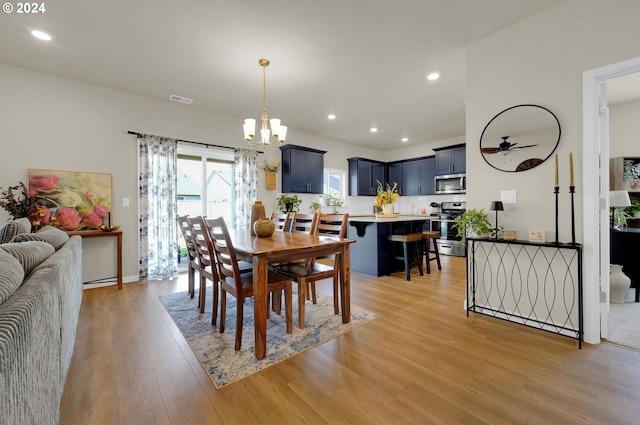 dining room with an inviting chandelier and light hardwood / wood-style flooring