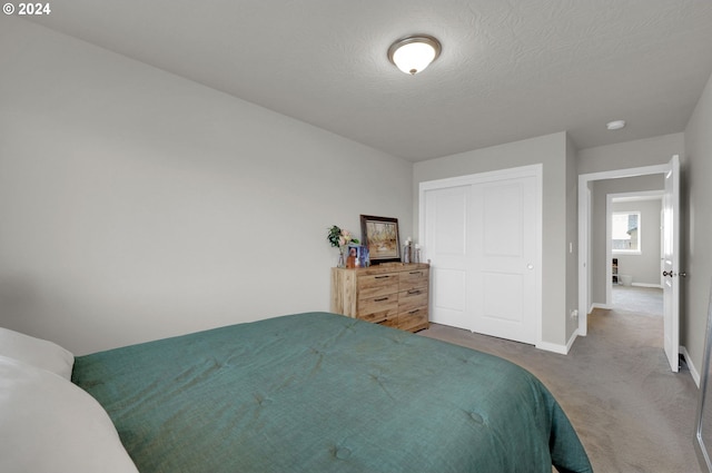 bedroom featuring carpet floors, a closet, and a textured ceiling