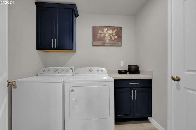 laundry area featuring separate washer and dryer, cabinets, and light wood-type flooring