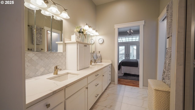 bathroom featuring vanity, decorative backsplash, and french doors