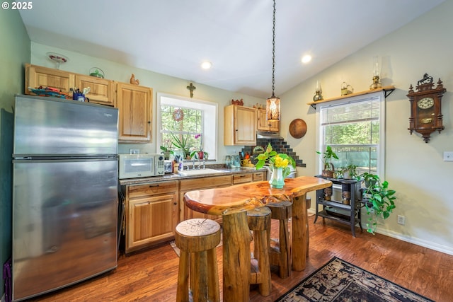 1274 Wild Mustang Ln, Gilchrist, OR 97737 - kitchen with freestanding refrigerator, white microwave, dark wood-type flooring, light brown cabinetry, and lofted ceiling