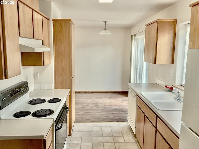 2732 SE 87th Ave, Portland, OR 97266 - kitchen featuring white appliances, under cabinet range hood, a sink, light countertops, and decorative light fixtures