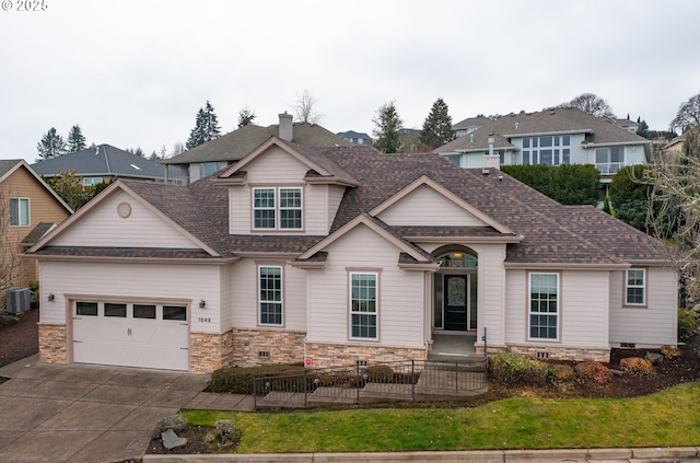 view of front of house featuring a garage and central AC