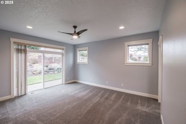 carpeted spare room with ceiling fan and a textured ceiling