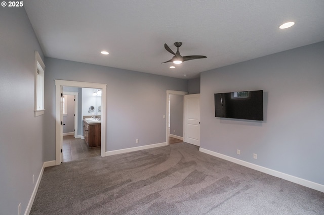 unfurnished bedroom with ensuite bathroom, carpet, and ceiling fan