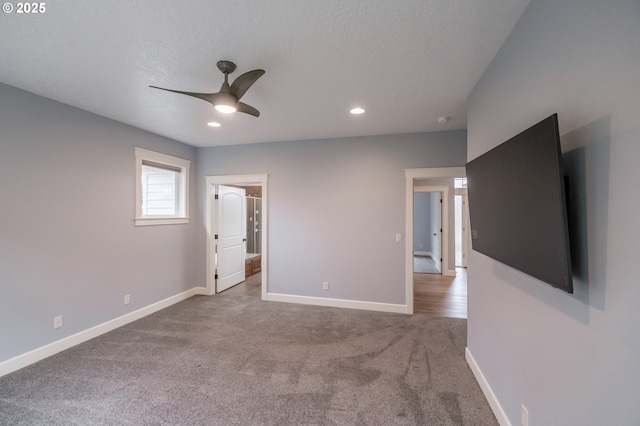 empty room with a textured ceiling, carpet floors, and ceiling fan