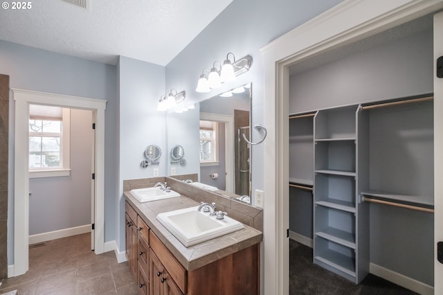 bathroom featuring vanity, tile patterned flooring, and a textured ceiling