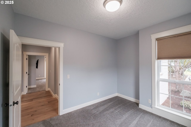 carpeted empty room featuring a textured ceiling