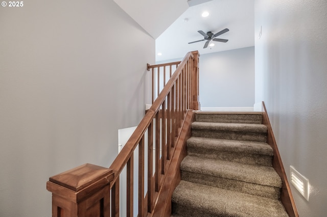 stairway with ceiling fan and lofted ceiling