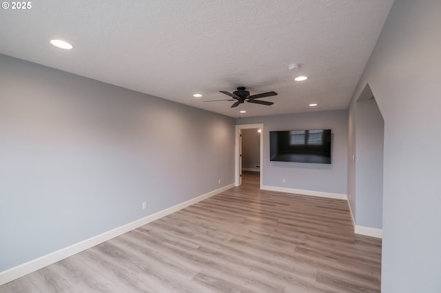 unfurnished living room featuring ceiling fan, a textured ceiling, and light wood-type flooring