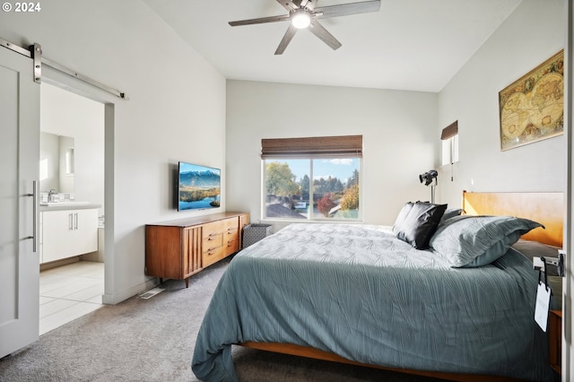 carpeted bedroom featuring sink, ensuite bath, vaulted ceiling, ceiling fan, and a barn door