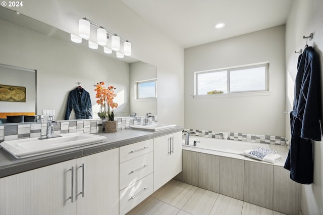 bathroom with vanity and tiled bath