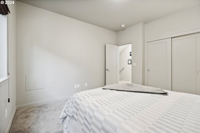 bedroom with light colored carpet and a closet