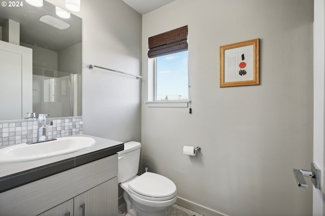 bathroom with vanity, a shower, toilet, and decorative backsplash