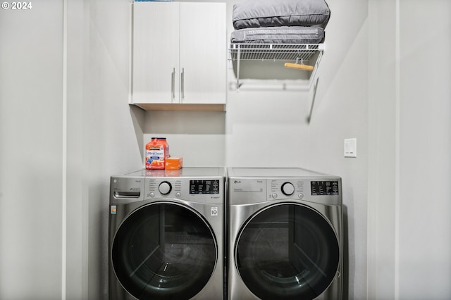 laundry room featuring cabinets and washer and clothes dryer