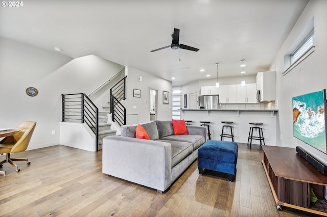 living room with light hardwood / wood-style floors and ceiling fan