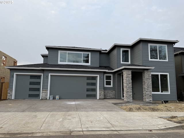 view of front of house with stone siding, driveway, and an attached garage