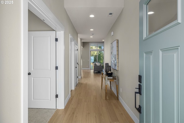 corridor featuring light wood-type flooring, baseboards, visible vents, and recessed lighting