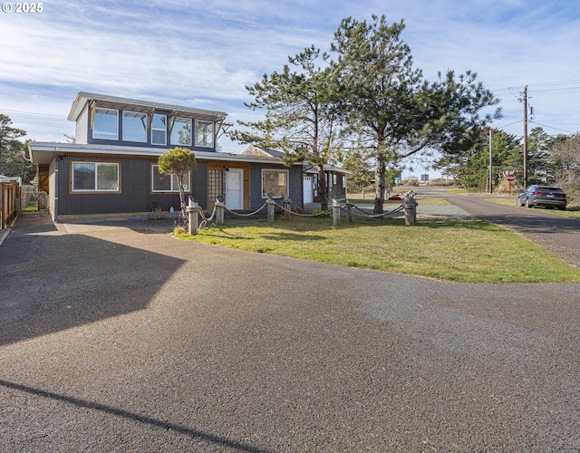 view of front facade featuring a front yard and fence