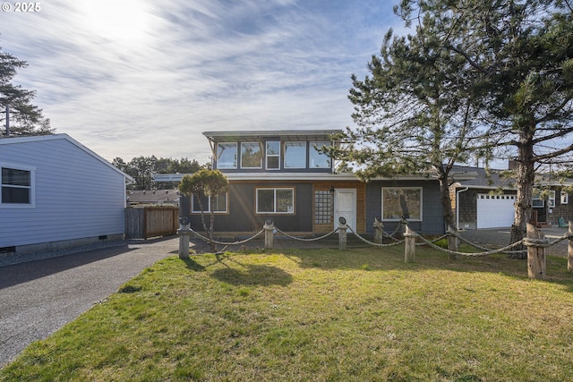 view of front of property with a garage, a front yard, driveway, and fence