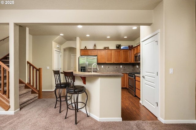 20937 SW Edgemont St, Beaverton, OR 97003 - kitchen featuring appliances with stainless steel finishes, recessed lighting, a kitchen island with sink, a breakfast bar, and decorative backsplash