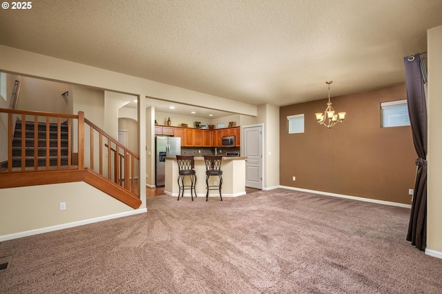 20937 SW Edgemont St, Beaverton, OR 97003 - unfurnished living room featuring carpet flooring, a chandelier, stairway, a textured ceiling, and baseboards