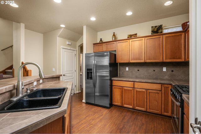 20937 SW Edgemont St, Beaverton, OR 97003 - kitchen with stainless steel appliances, a sink, dark wood-style flooring, tile counters, and brown cabinets