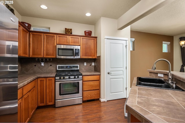 20937 SW Edgemont St, Beaverton, OR 97003 - kitchen with appliances with stainless steel finishes, tile countertops, a sink, brown cabinetry, and recessed lighting