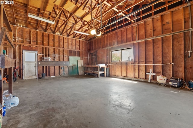 miscellaneous room featuring a towering ceiling and concrete flooring